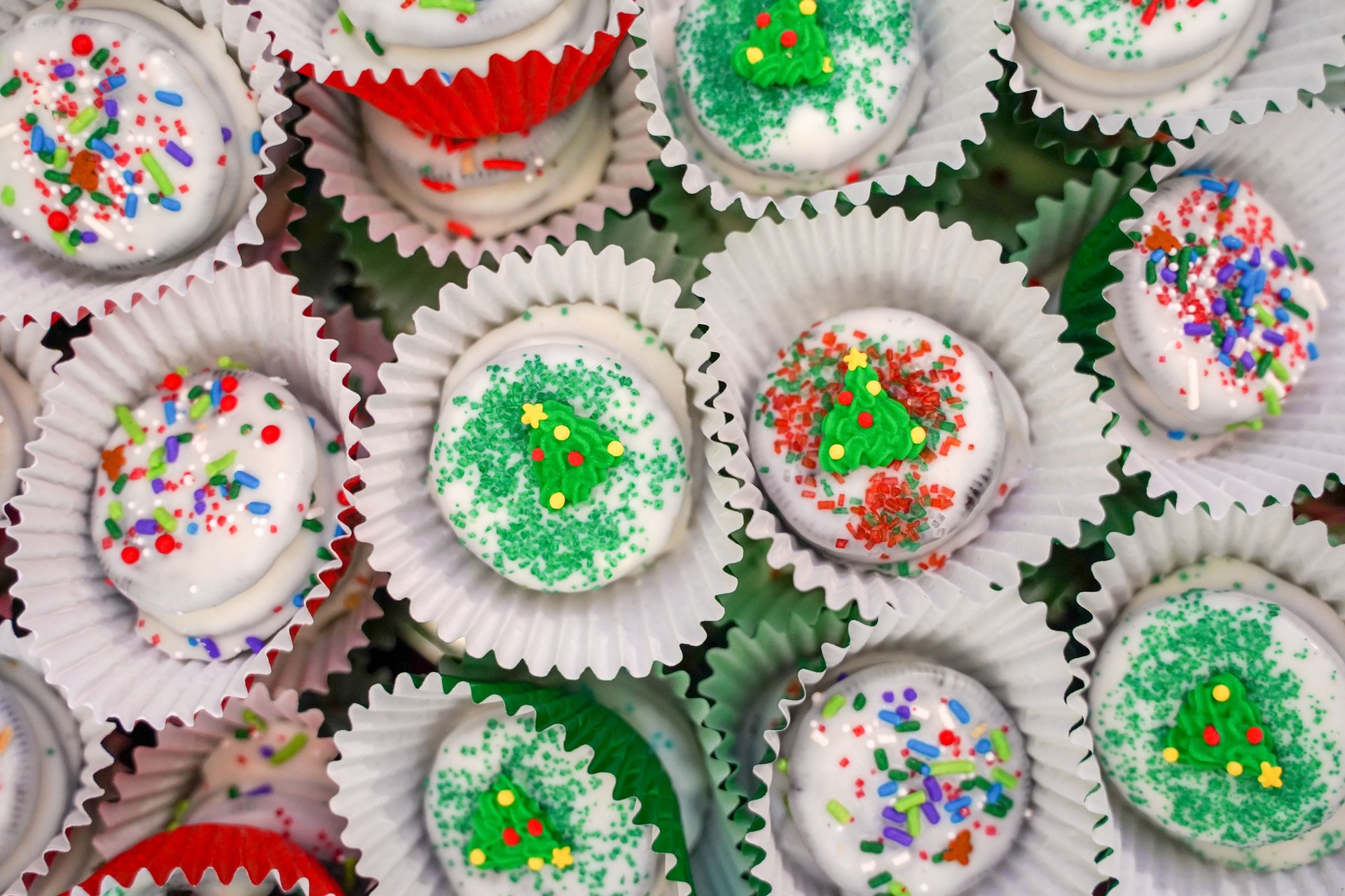 White chocolate dipped cookies decorated and packaged for Christmas, with sugar sprinkles and jimmies