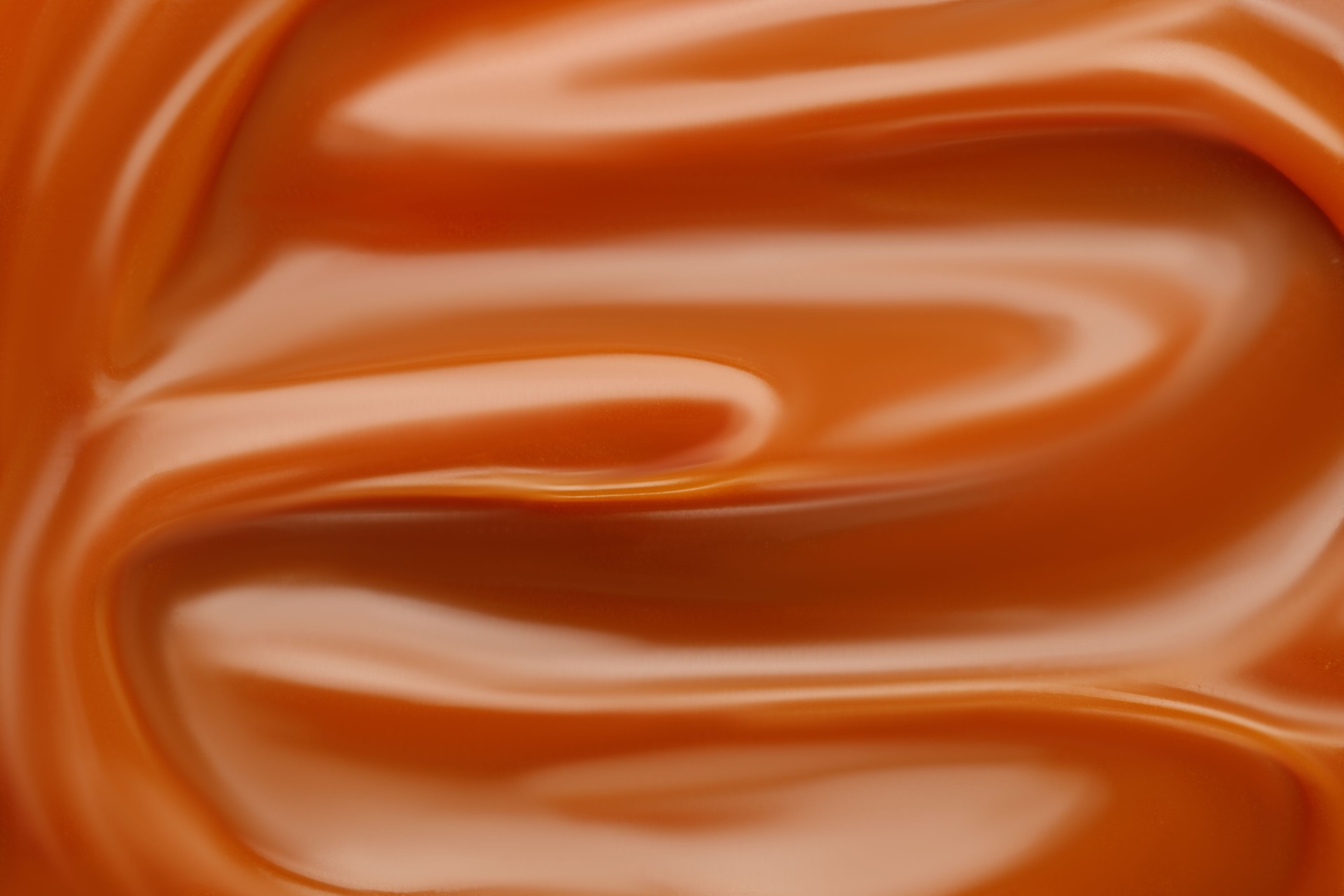 Liquid caramel syrup. Background of caramel paste. Texture Close up, top view.